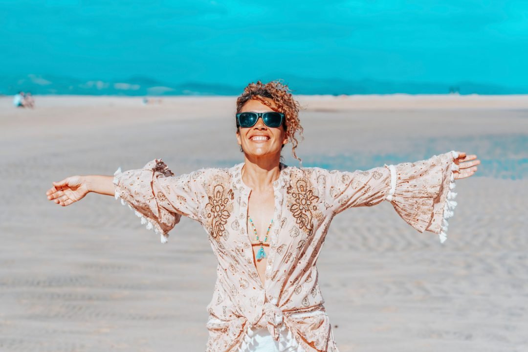 Woman with arms outstretched on beach
